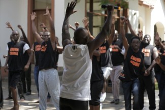 Sammy Ombisa Recovery Ally & Certified Wellness Coach(in white), Instructing men through exercises. exercises.