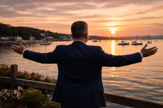 Community leader overlooking Oyster Bay harbor at sunset, representing the role of local leadership in supporting addiction recovery across New York