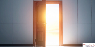 a opening door with sun coming in through it against a tile wall 